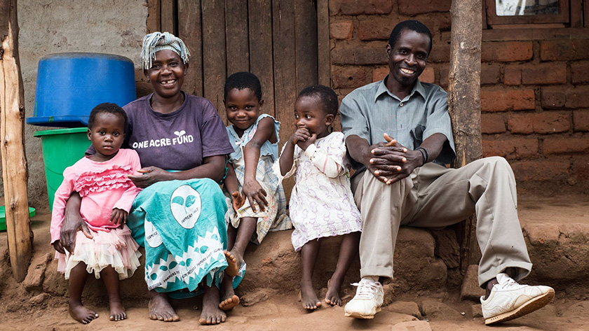 Fainess Maganga with her husband Paul and their grandchildren Colin, Sylvia, and Hope, sitting in front of their family home in Malawi. 
