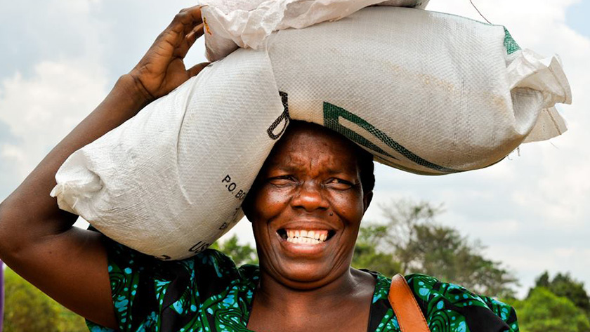 Nuru Babirie, a Ugandan Farmer takes her seed and fertilizer home, smiling all the way.