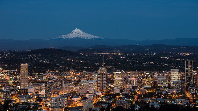 Portland skyline at dusk with snow-capped Mt. Hood in the distance 