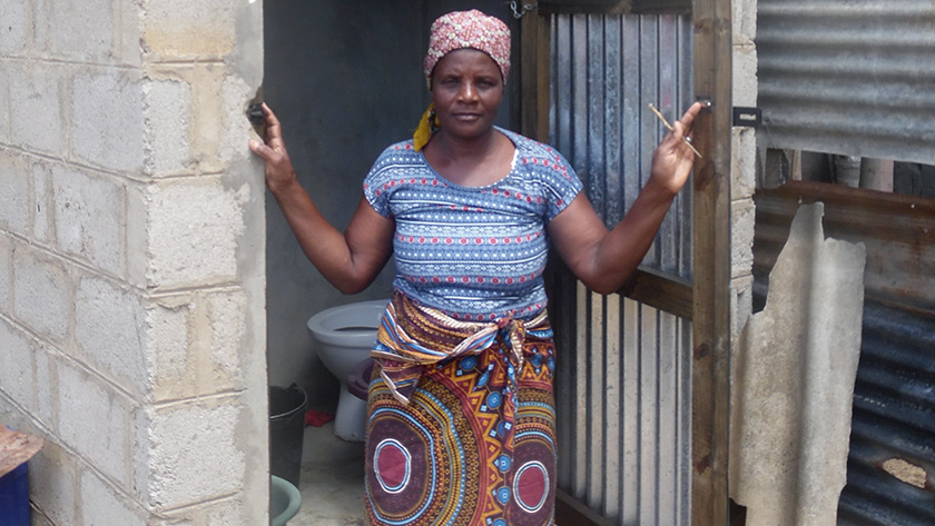 Alice Timane standing in front of new WSUP communal toilet