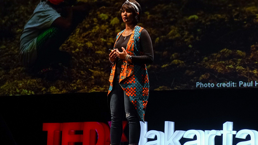 A speaker presents from the stage at TEDxJakarta