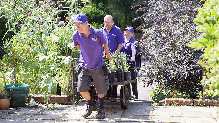 Members of Thrive, founded by the author 41 years ago, working in the Headquarters Gardens two young men and a young woman pulling a wagon full of plants. 