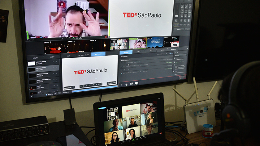 Photo of the control room of the TEDx Sao Paulo event with multiple screens and zoom participants live