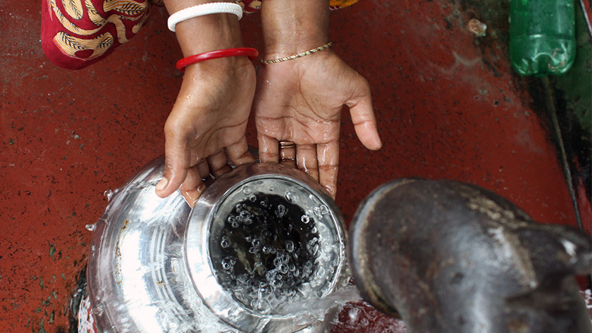 A woman's hands filling a jug with clean water