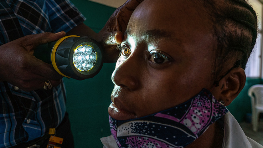 Monrovia, Liberia - During an EYElliance vision screening activity, a guidance counselor checks the eyes of a student. Eye Alliance and partners trained school staff members to conduct vision screening activities in which they flag students who may have vision impairment.