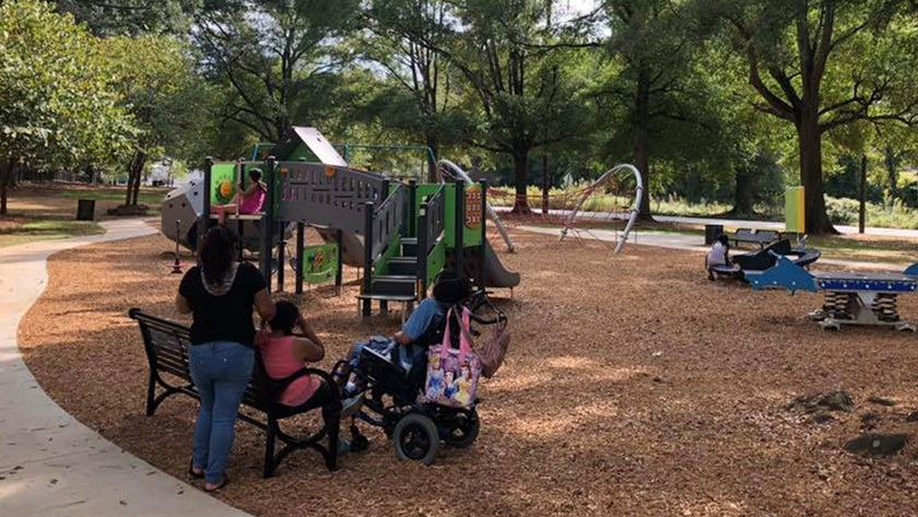 A family at the Sara J. González Memorial Park all-abilities playscape 