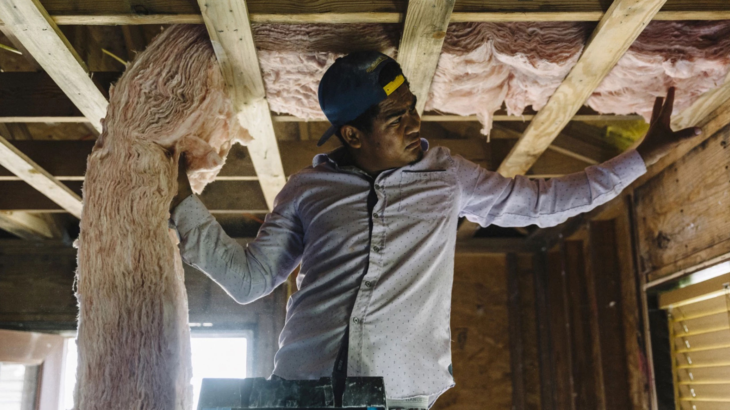 A worker installing insulation