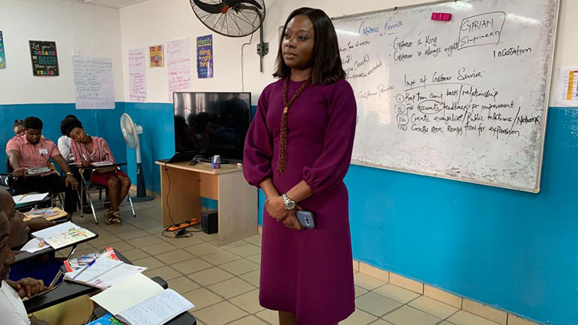 Molade Adeniyi, Chief Executive Officer, WAVE, at the front of a high school classroom